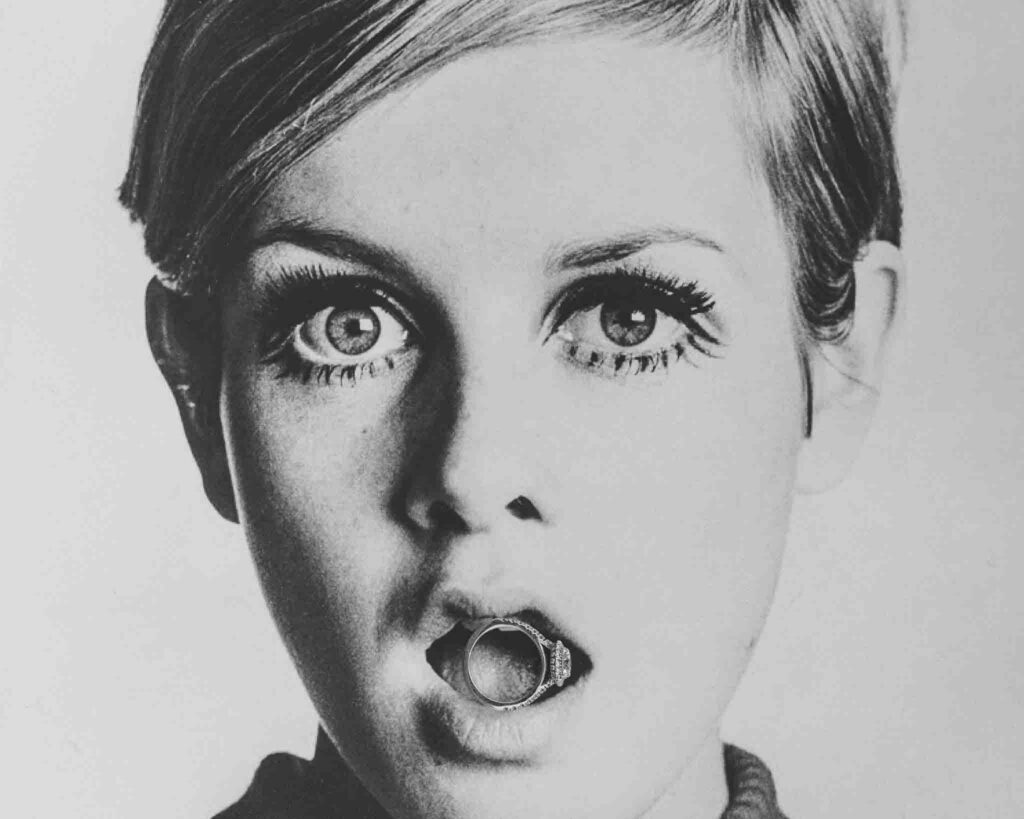 A wedding ring placed in the mouth of a classic Twiggy photo.